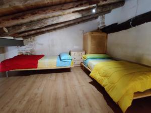 2 camas en una habitación con suelo de madera en Loft Apartamento Rural La Fresneda - Casa Vidal, en La Fresneda