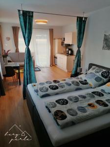 ein Schlafzimmer mit 2 Betten und ein Wohnzimmer in der Unterkunft Bergperle Apartments & Mountain Sport in Fliess