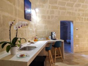 a kitchen with a sink and a counter with stools at Loggia delle stelle in Matera