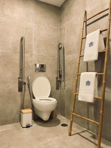 a bathroom with a toilet and a ladder and towels at Behappy Lodge & Brunch in Esmoriz +33 photos
