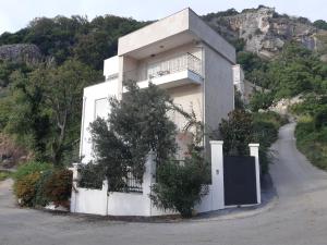 ein weißes Haus mit einem Tor und einem Zaun in der Unterkunft Apartments Villa Simonovic in Petrovac na Moru