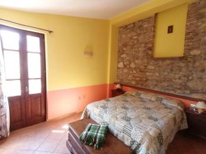 a bedroom with a bed and a stone wall at Casale Le Due Querce in Ferentillo