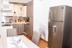 a kitchen with a stainless steel refrigerator and white cabinets at Da Ale alla Cattedrale in Palermo