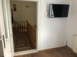 a hallway with a television hanging on a wall at Cabana Felyviss in Gîrda de Sus +26 photos