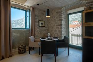 a dining room with a table and chairs and a window at Apartments Gabela in Risan