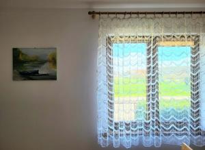 uma cortina numa janela num quarto em Słoneczna Dolina nad Biebrzą em Goniadz