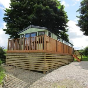 a large house with a deck on top at Barnkirk Holidays in Newton Stewart
