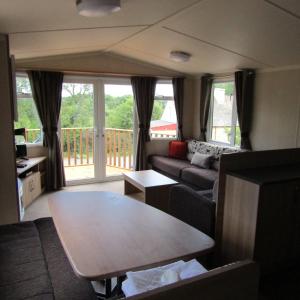 a living room with a couch and a table at Barnkirk Holidays in Newton Stewart
