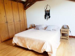 - une chambre avec un grand lit blanc dans l'établissement Gîte de la Ferme Florale Ponoie, à Chezal-Benoît