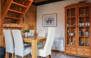 a dining room with a wooden table and white chairs at 3 Bedroom Cozy Home In Extertal in Extertal