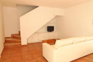 sala de estar con sofá blanco y TV en Apto en Residencial El Bosque, en Chiclana de la Frontera