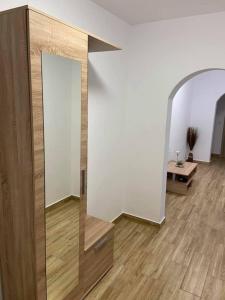Camera con specchio e pavimento in legno. di Apartament Diana a Jurilovca