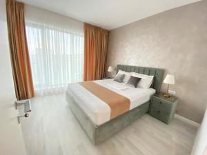 a bedroom with a bed and a large window at Zeita din Bel-Air, Mamaia Nord in Mamaia