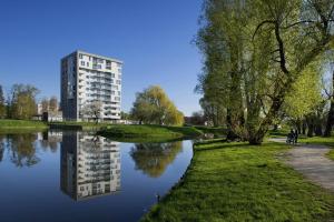 Ein Gebäude spiegelt sich im Wasser eines Flusses wider in der Unterkunft ParkView Apartment in Danzig