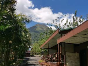 a house with a mountain in the background at Hotel Palmera Real Hot Springs in Fortuna