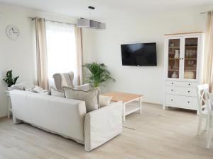uma sala de estar branca com um sofá branco e uma mesa em SlowHouse - dom z własną sauną! em Kopalino