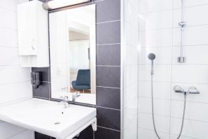 a bathroom with a sink and a mirror at Lavik Fjord Hotel & Apartments in Lavik