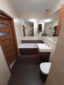 a bathroom with a tub and a toilet and a sink at ParkView Apartment in Gdańsk +16 photos