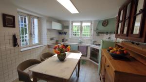 a kitchen with a table with a vase of flowers on it at Natura e Arte in Pavullo nel Frignano