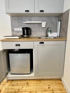 a kitchen with a sink and a microwave at Apartament na Nadmorskiej in Grzybowo