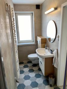 a bathroom with a toilet and a sink and a mirror at Apartament na Nadmorskiej in Grzybowo