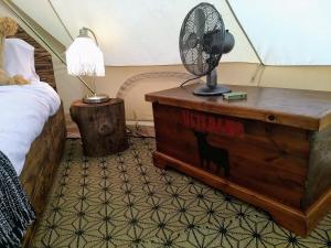 a bedroom with a bed and a fan on a dresser at Romantic Safari tent in Tortosa +3 photos
