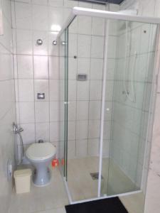 ein Badezimmer mit Glasdusche und Toilette in der Unterkunft Sala living vista mar Wi-fi e smart tv in São Vicente