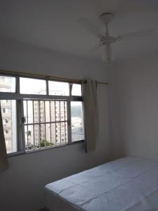 ein Schlafzimmer mit einem Bett und einem Fenster mit Aussicht in der Unterkunft Sala living vista mar Wi-fi e smart tv in São Vicente