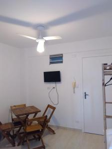 ein Wohnzimmer mit Tisch und Stühlen und einem Deckenventilator in der Unterkunft Sala living vista mar Wi-fi e smart tv in São Vicente