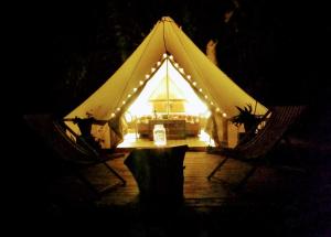 a tent with a table and two chairs at night at Romantic Safari tent in Tortosa