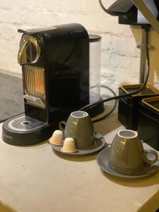 una mesa con dos tazas de té y una cafetera en SLEEP INN - Industrial Flat Citycenter, en Amberes