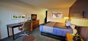 a hotel room with a bedroom with a bed and a desk at Economy 7 Inn- Newport News in Newport News