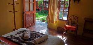 a bedroom with a bed and a door and a chair at B&B Sun Gate in Ollantaytambo