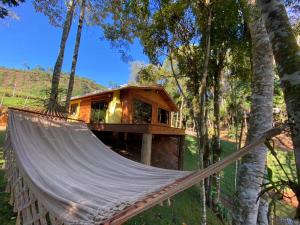 a hammock in front of a tree house at Recanto Della Mata in Venda Nova do Imigrante