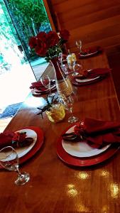 a wooden table with plates and glasses and red napkins at Recanto Della Mata in Venda Nova do Imigrante
