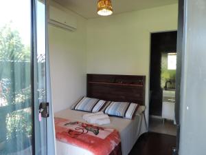 Un pequeño dormitorio con una cama con toallas. en Pousada Casa de Ferro, en Passo de Torres