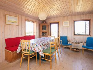 GrønhøjにあるThree-Bedroom Holiday home in Løkken 31のダイニングルーム(テーブル、椅子付)