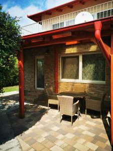 a patio with chairs and a table in front of a building at Rozmaring Pihenőház in Velence