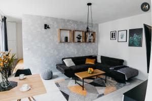 a living room with a black couch and a table at AH Mlynská Bašta I in Košice