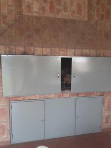 a room with three white cabinets in a brick wall at La casa deMarta in Córdoba