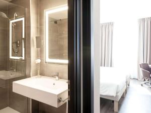 a bathroom with a sink, toilet and bathtub at Novotel Brescia Due in Brescia