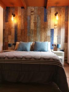 a bedroom with a large bed with a wooden wall at Casa Adeyu in Tuineje