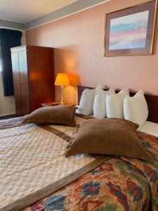 a hotel room with a large bed with pillows at Value Lodge Inn in Delta