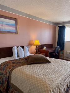 a hotel room with a bed and a desk at Value Lodge Inn in Delta