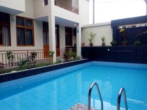 a swimming pool in front of a building at Hostal La Maison Canadiense in San Ramón +4 photos