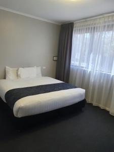 Ein Bett oder Betten in einem Zimmer der Unterkunft Madison Capital Executive Apartments