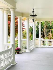 a white porch with white columns and flowers at Vida Boutique Inn in Worcester