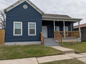 une maison bleue avec une terrasse couverte et des escaliers. dans l'établissement Cozy *Downtown Getaway*, à San Antonio