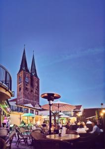 um grande edifício com uma torre de relógio ao fundo em Hotel Schwarzer Adler Stendal em Stendal