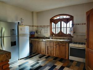 una cucina con un frigorifero bianco e una finestra di Sitio Carvalho da Serra a Caeté